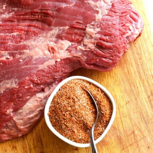 Seasoning a brisket with a homemade rub before smoking.