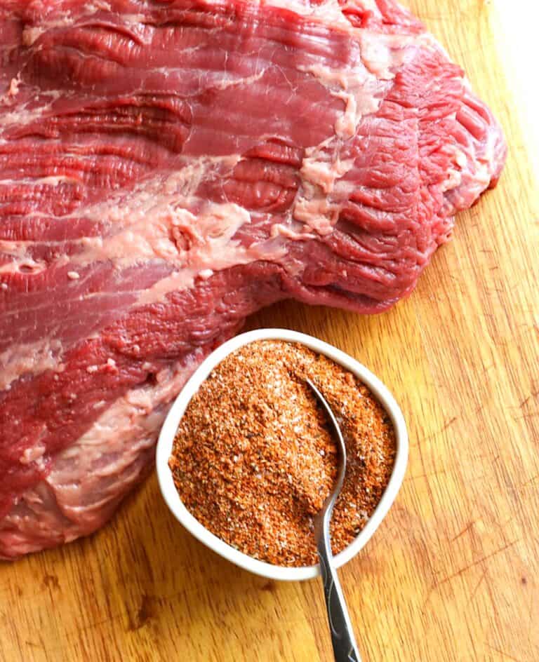 Seasoning a brisket with a homemade rub before smoking.