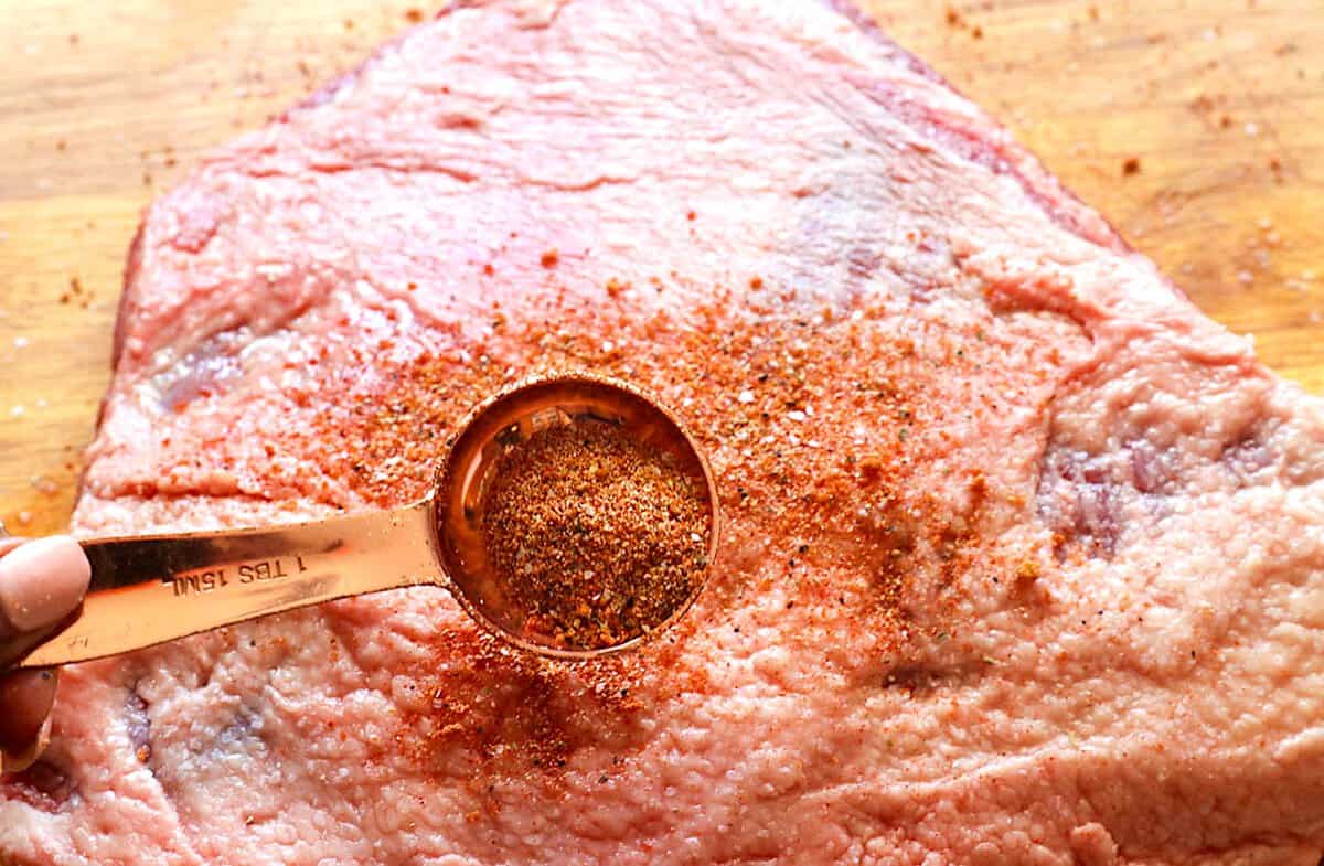 Coating a brisket with the homemade rub before smoking (or roasting it in the oven).