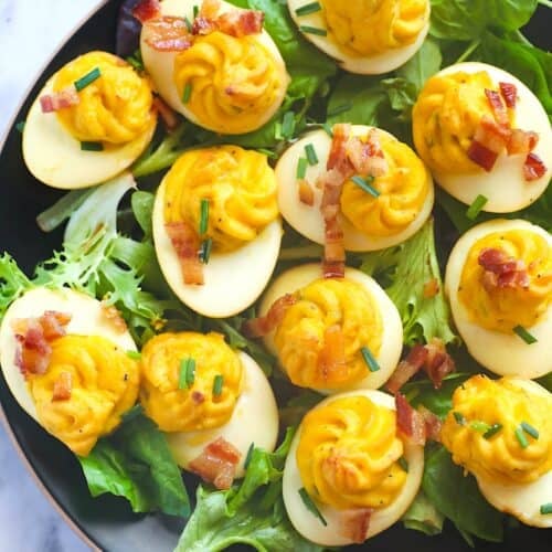 Serving up a platter of smoked deviled eggs topped with bacon for a family picnic.