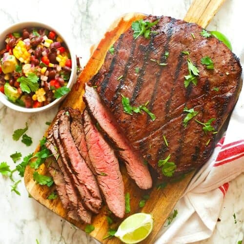 Slicing into a perfectly smoked and reverse seared flank steak. Black bean and corn salsa sits on the side ready and waiting.