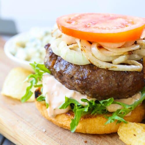 Putting a burger together for an amazing backyard burger experience.