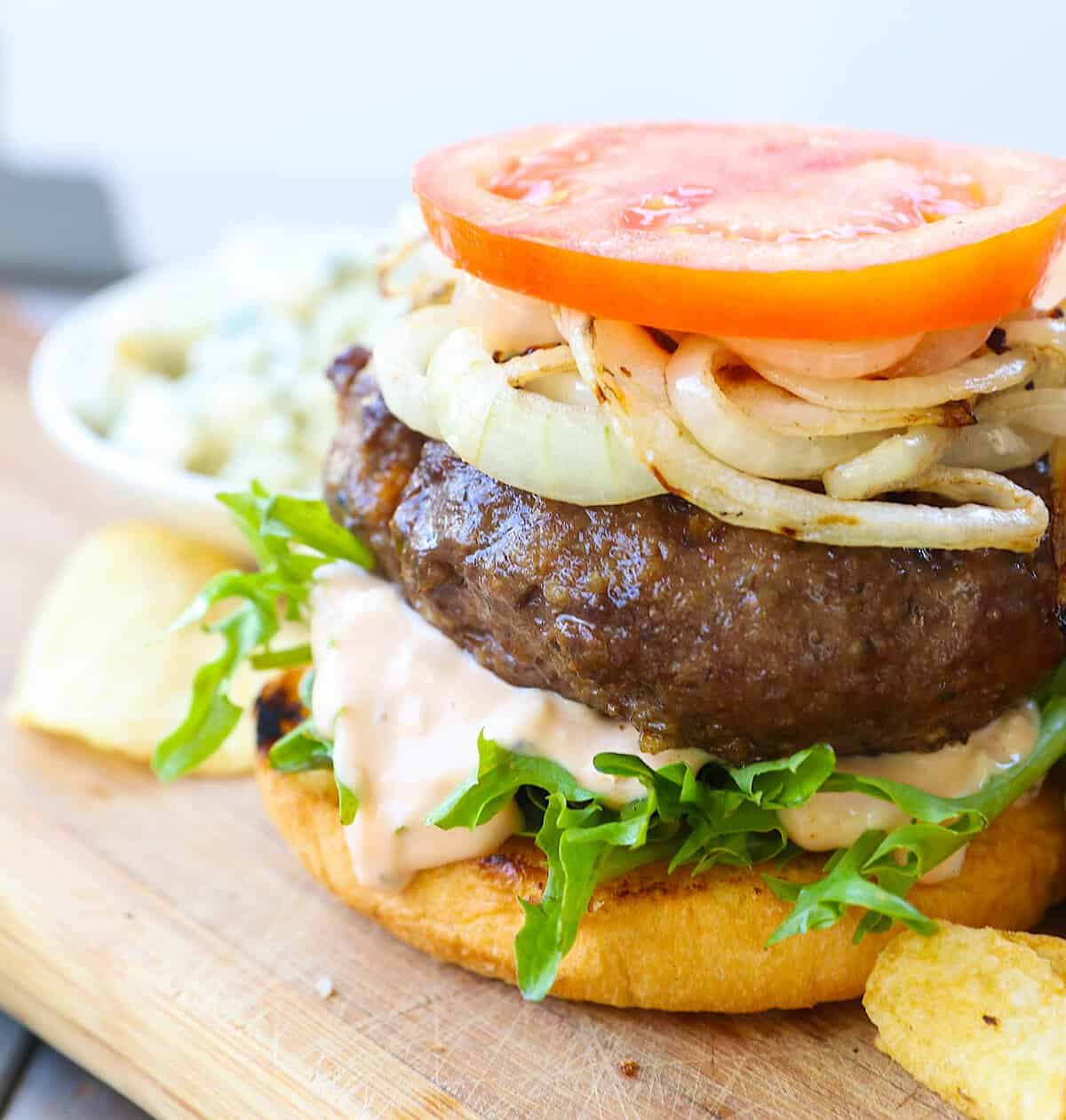 Putting a burger together for an amazing backyard burger experience.