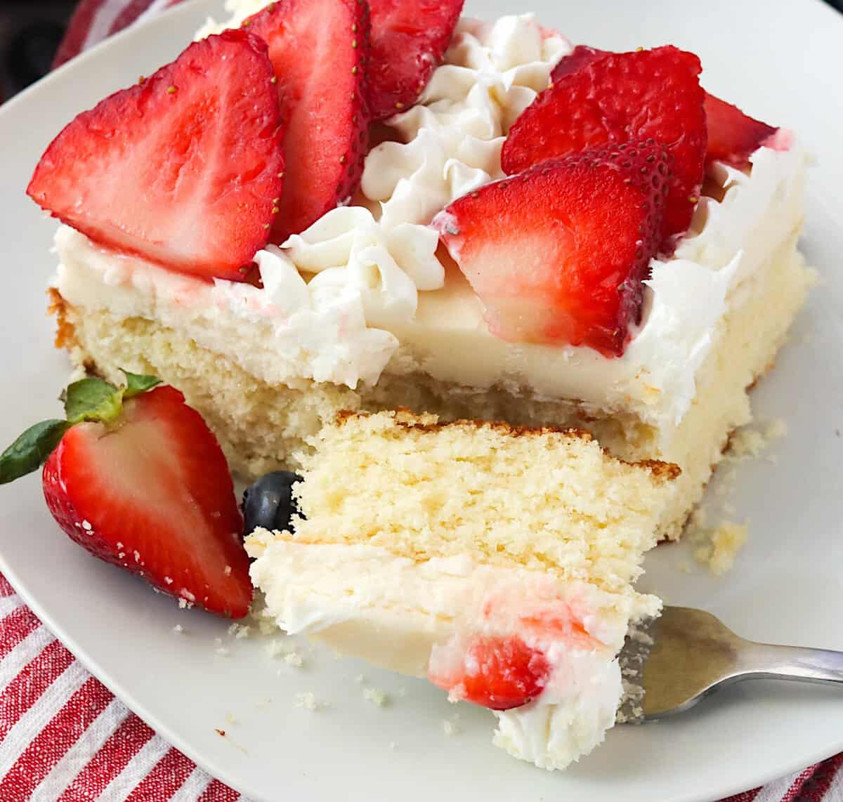 Forking into a decadent slice of vanilla cake decorated for the 4th of July.