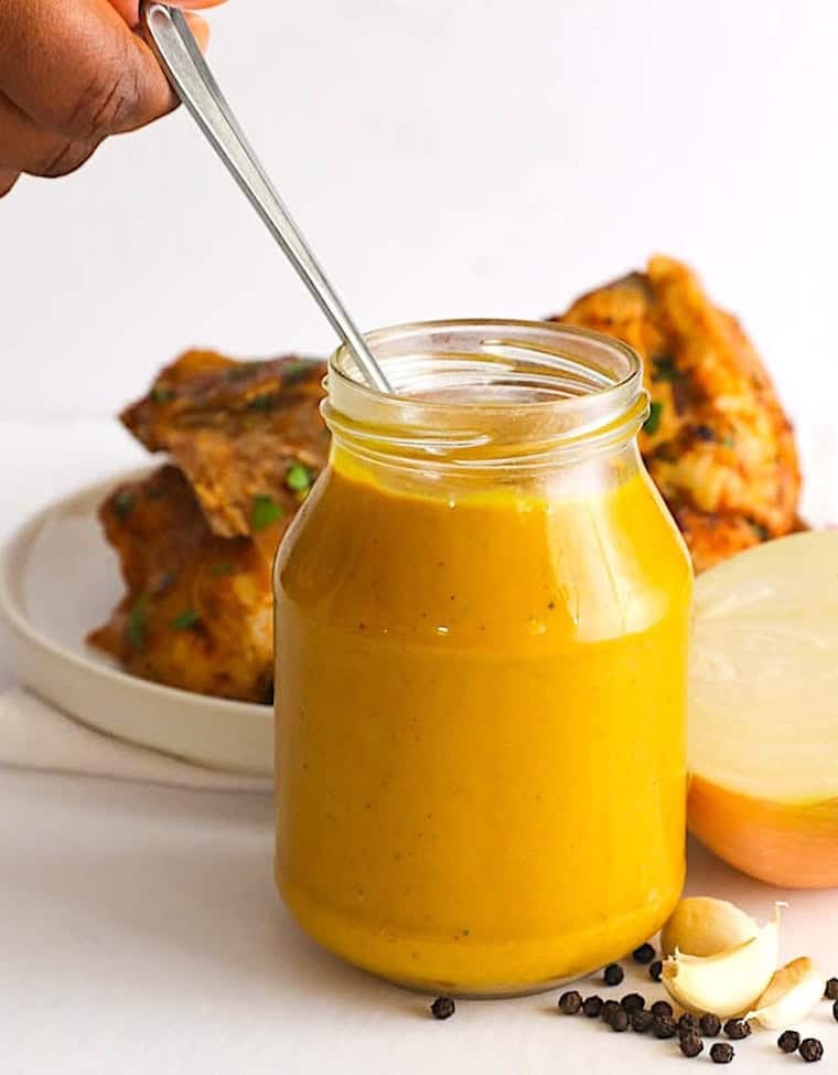Serving up jar of mustard BBQ sauce with fried chicken for a delicious soul food dinner.