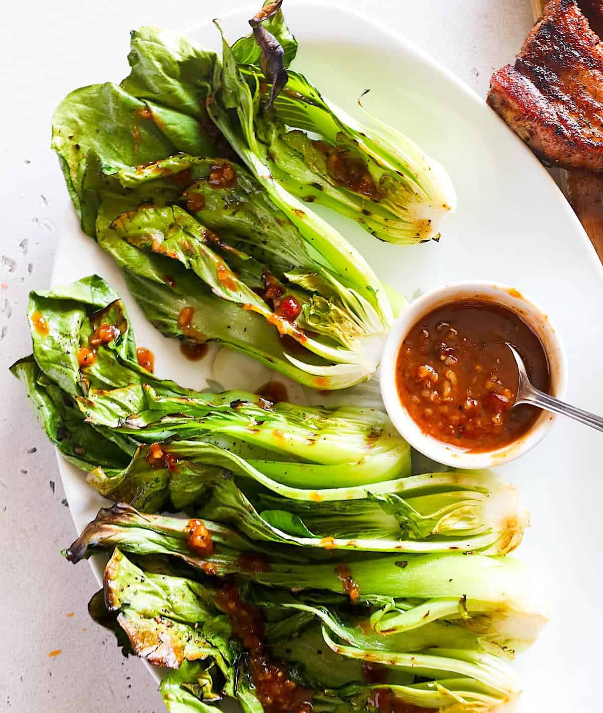 Drizzling tender, crispy bok choy with a spicy sauce.