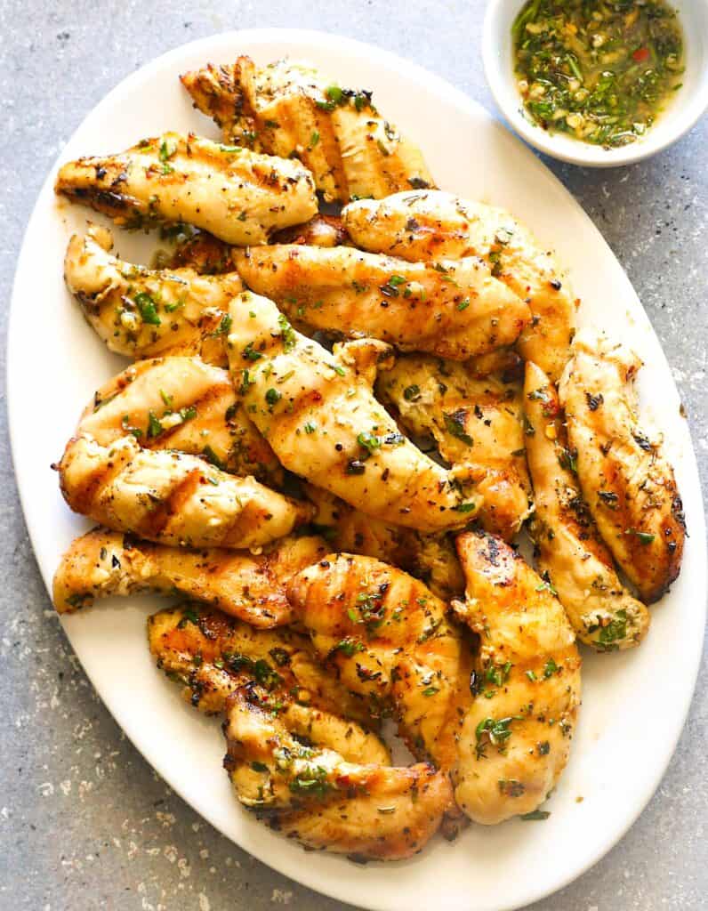 Serving up a platter filled with juicy, smoky, and freshly grilled chicken tenders.