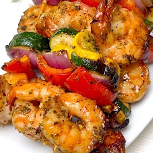 A closeup on tender, perfectly grilled shrimp on skewers.