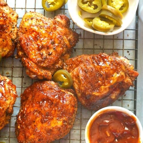 Amazing, smoky pellet grilled chicken thighs slathered with homemade BBQ sauce ready to serve up to a happy family.