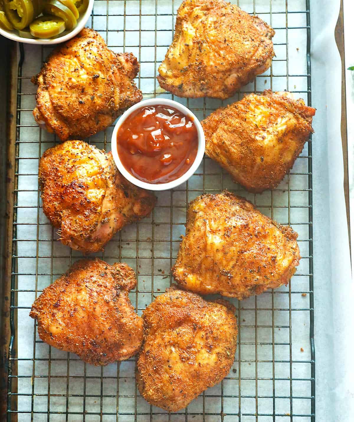 Freshly smoked chicken thighs with BBQ sauce on a rack and ready to enjoy.