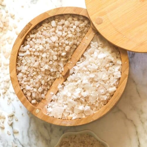 A lidded wooden bowl loaded with two types of smoked salt.