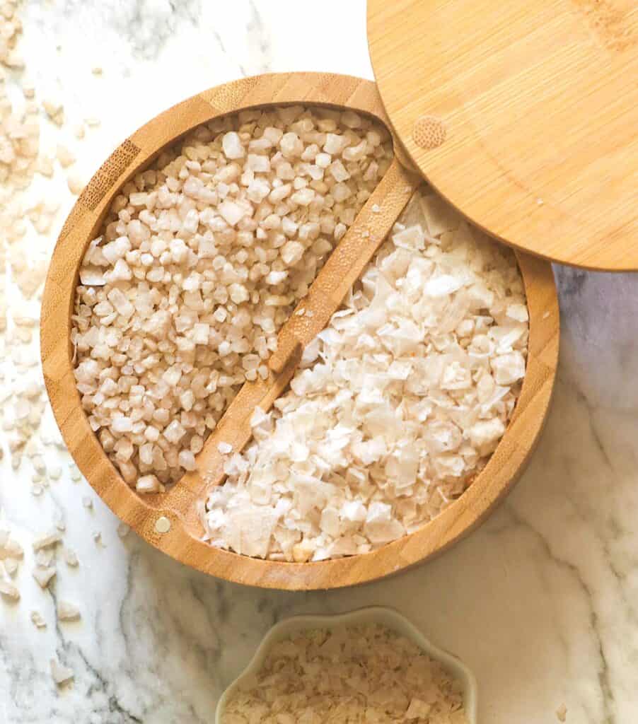 A lidded wooden bowl loaded with two types of smoked salt.