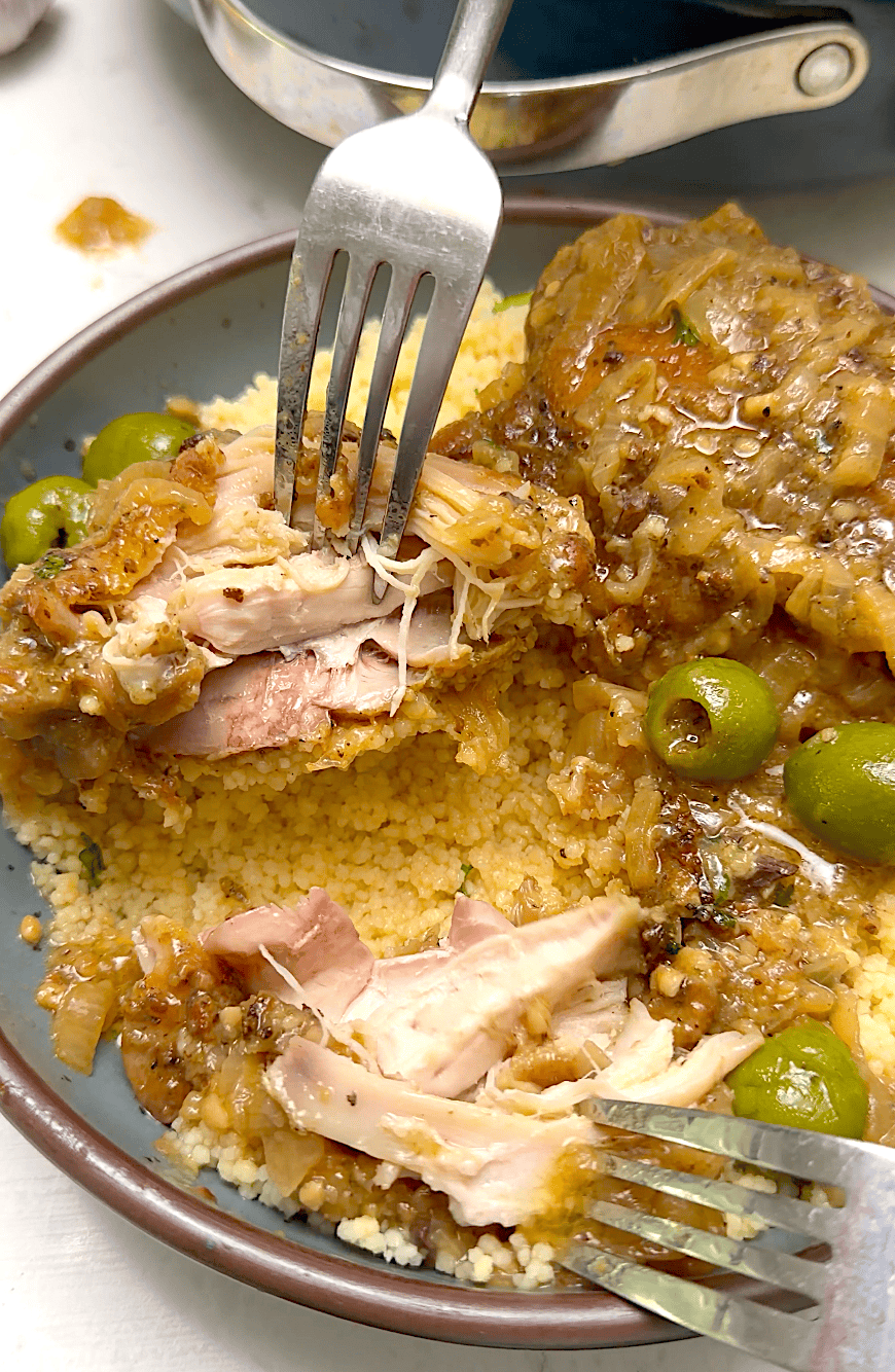 Forking into a tender, juicy chicken thigh simmered in a yassa sauce.