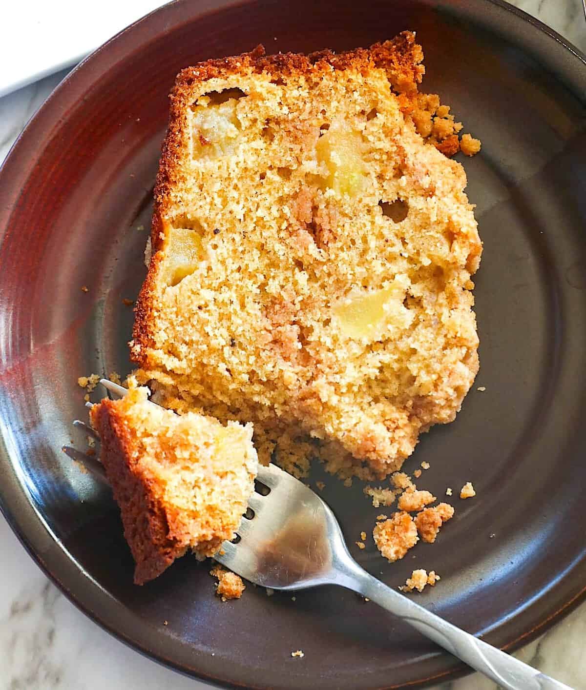 Forking into a slice of fresh apple bread with streusel topping.