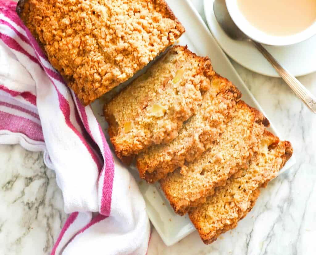 Sliced apple bread with coffee provides a tempting fall holiday vibes.