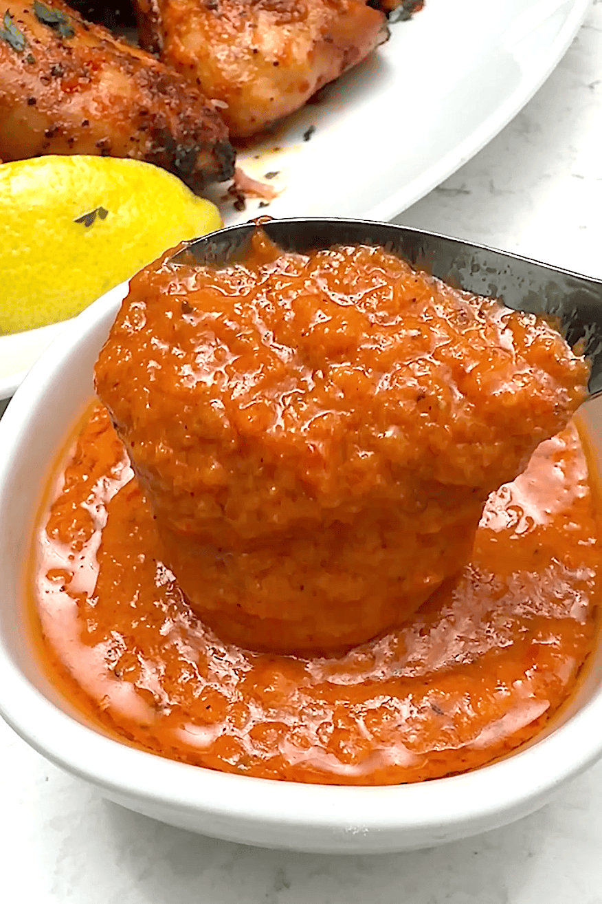 Scooping up delicious hot sauce made with peri peri peppers.