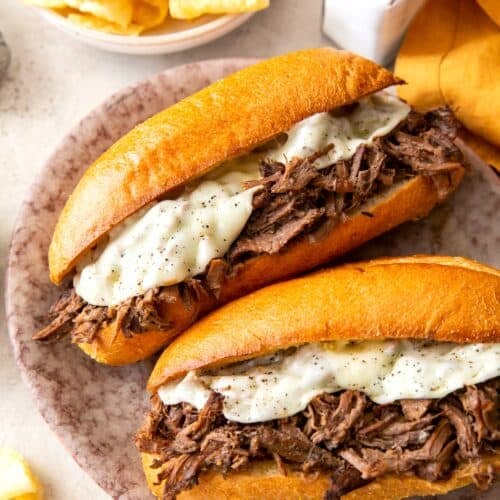 A mouthwatering slow cooker French dip sandwich ready to enjoy with potato chips.