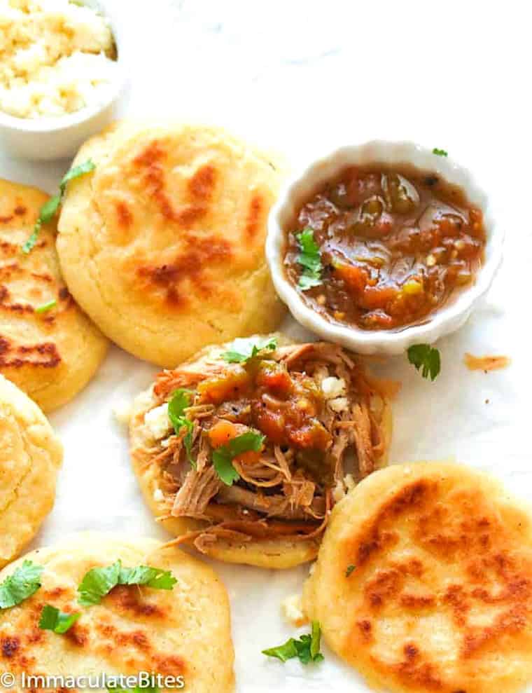 Freshly made Venezuelan arepas made thinner and topped with shredded beef.