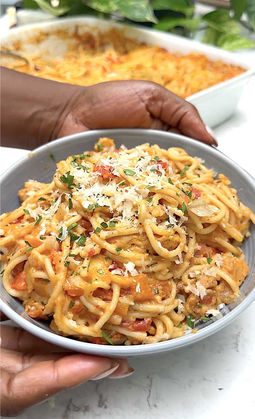 Serving up steaming hot chicken spaghetti fresh from the oven and topped with grated Parmesan cheese.