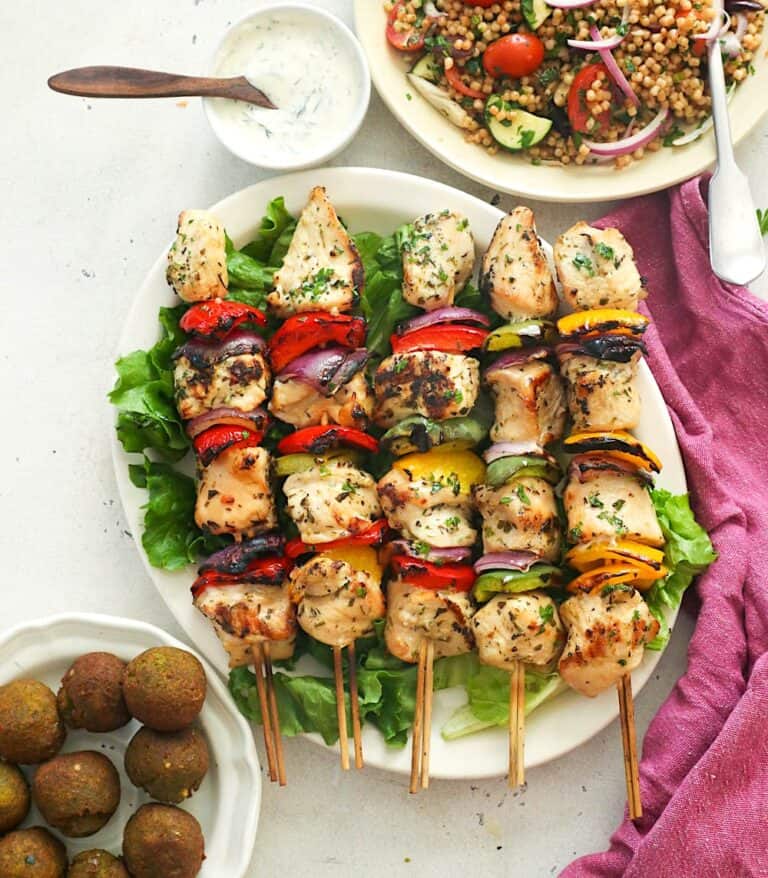 Serving up grilled chicken kabobs with falafel, dill sauce, and couscous for an amazing Mediterranean meal.