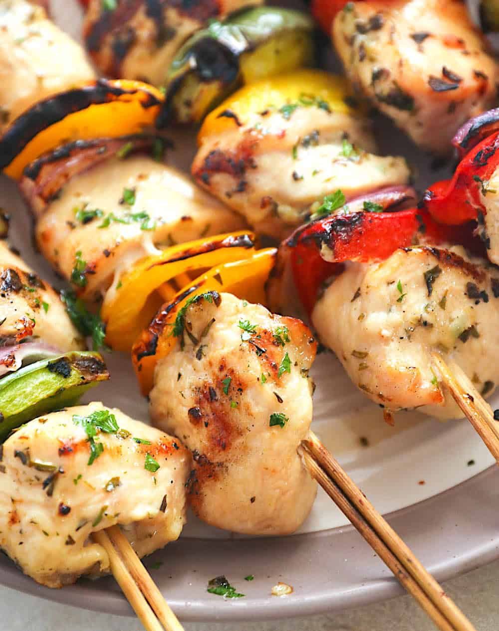 Showing off a closeup of perfectly grilled kabobs loaded with chicken and vegetables.