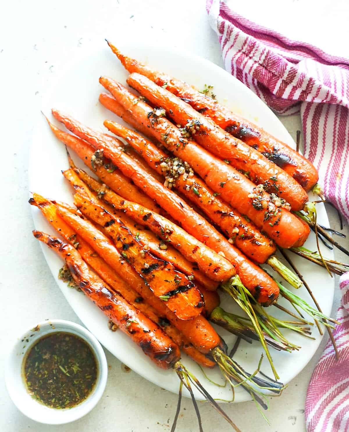 A platter of freshly grilled carrots with brown butter on the side for a healthy side dish.