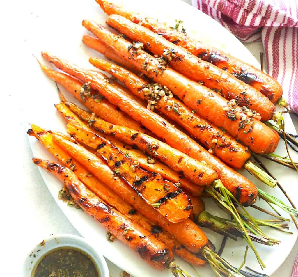 Serving herbed brown butter on the side with a platter of freshly grilled carrots.