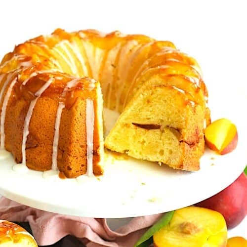 Slicing up a freshly baked and cooled peach cobbler pound cake for a decadent summer dessert.