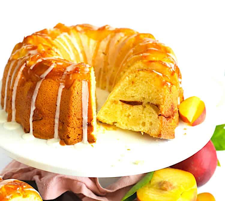 Slicing up a freshly baked and cooled peach cobbler pound cake for a decadent summer dessert.