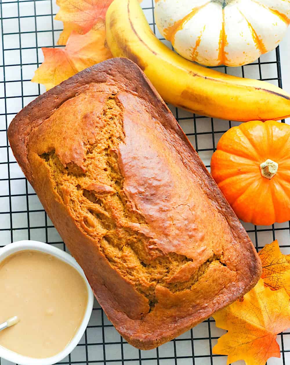 Freshly baked and cooled pumpkin banana bread ready to be drizzled with the decadent glaze for a delightful fall treat.