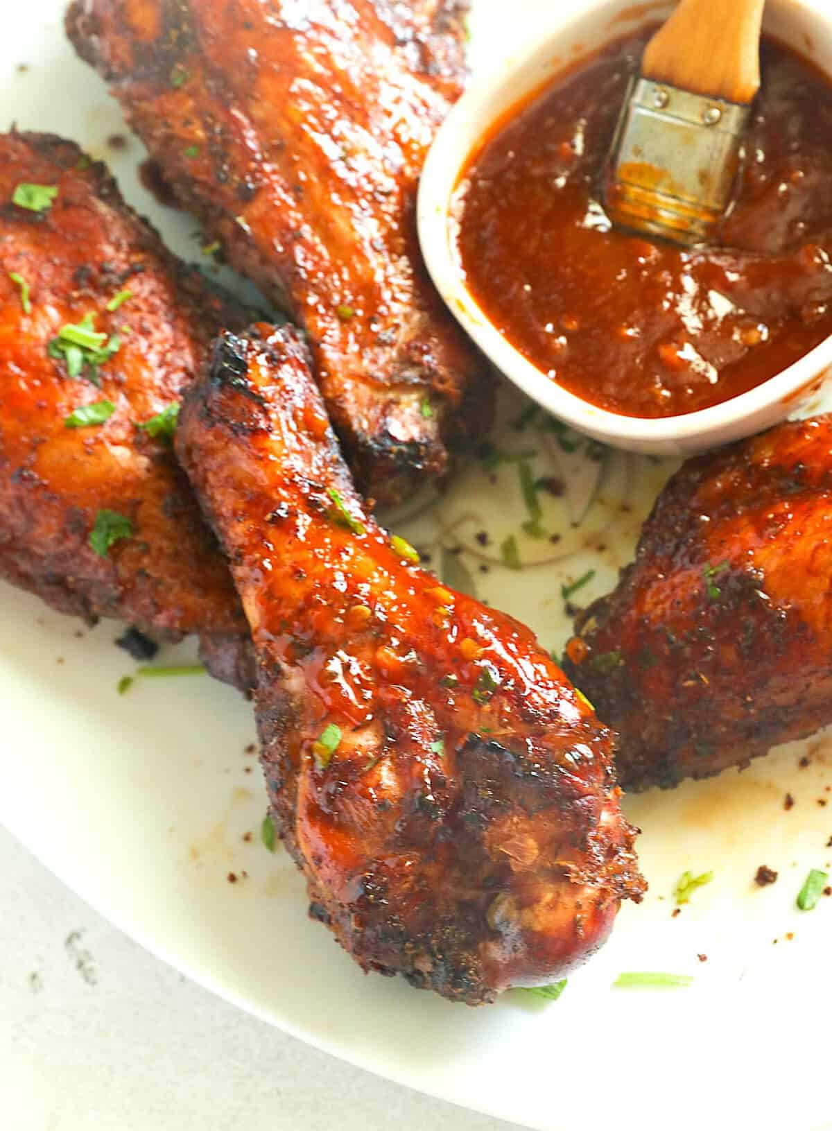 Basting smoky, fall-off-the-bone tender turkey wings with BBQ sauce.