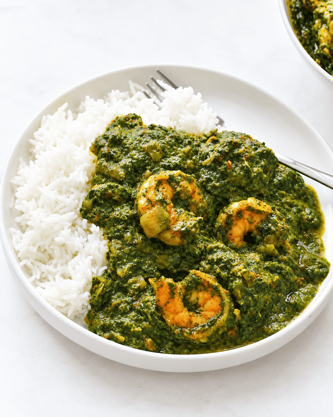 Serving hot cassava leaf soup over white rice. The shrimp is an added bonus.