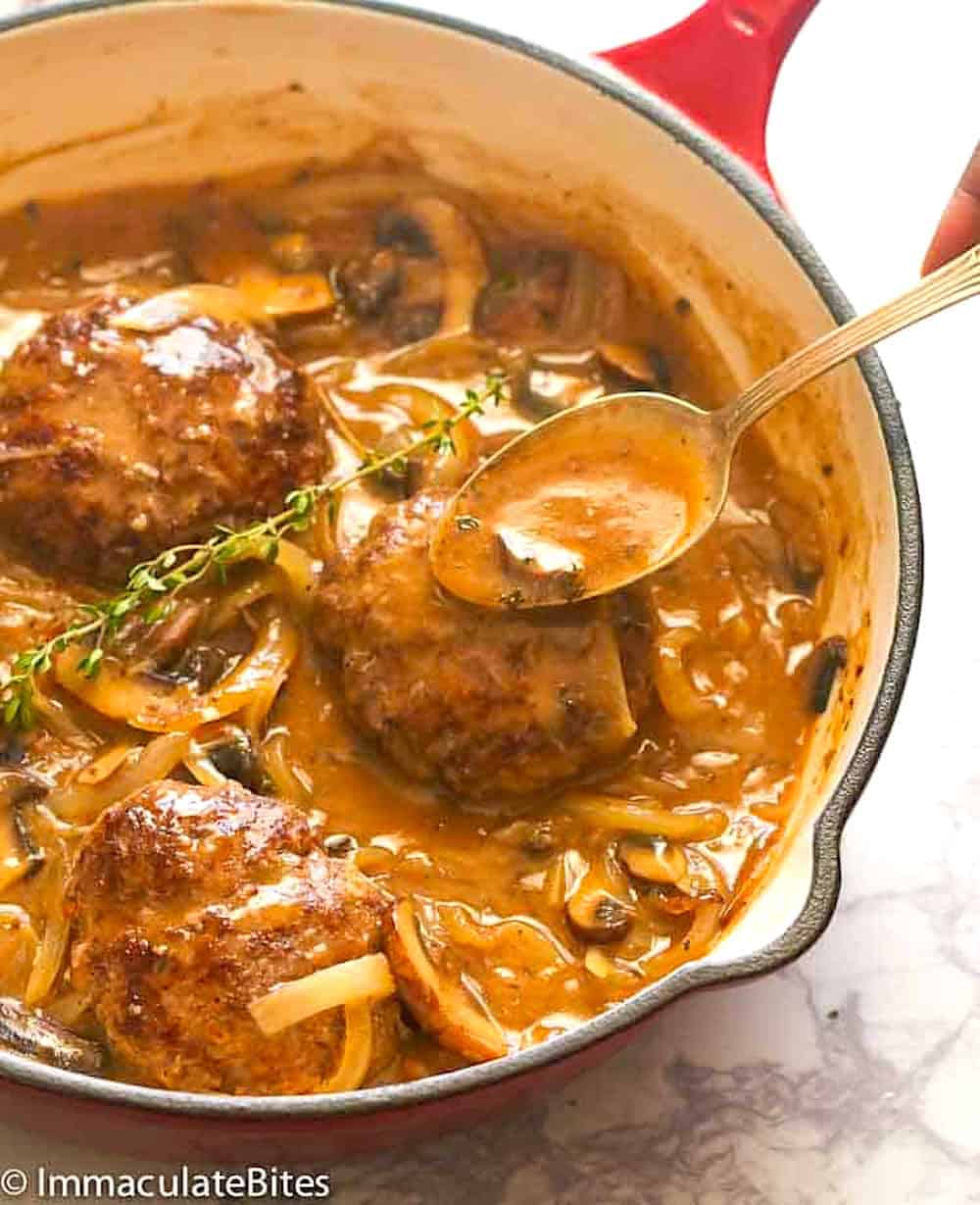 Spooning up delectable gravy over hamburger steak for an economical family meal.