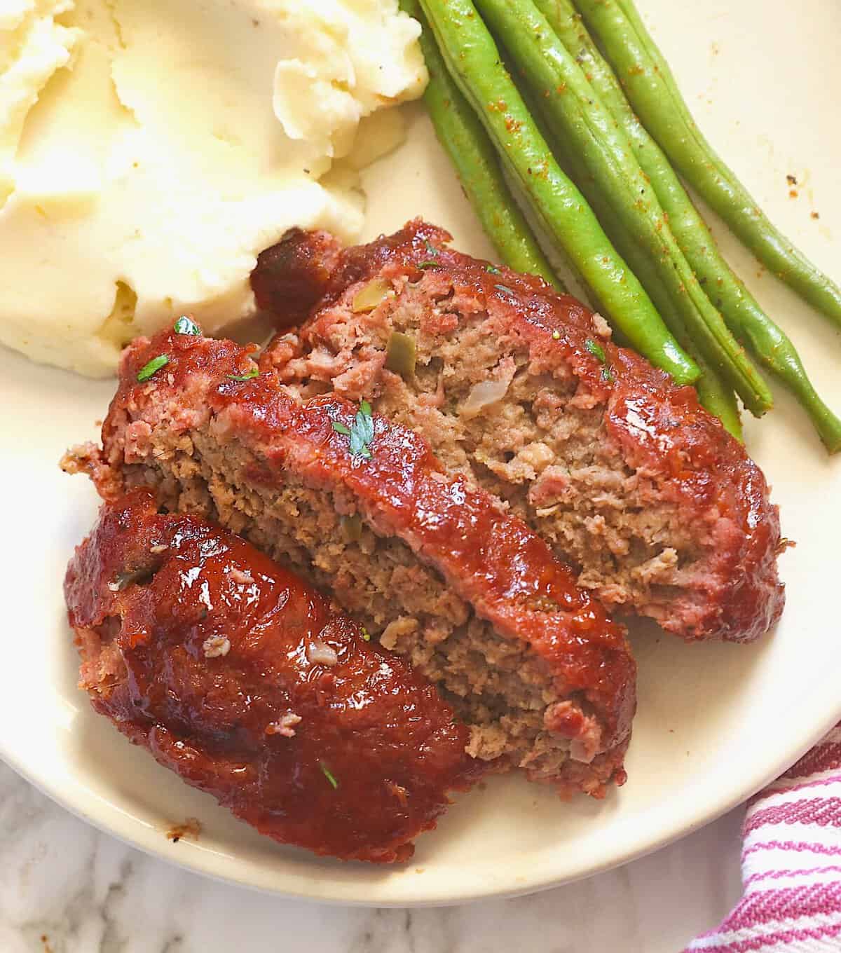 Enjoying a serving of pellet grilled meatloaf with mashed potatoes and green beans. 