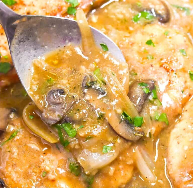 Spooning mushroom gravy over tender, smothered turkey chops.