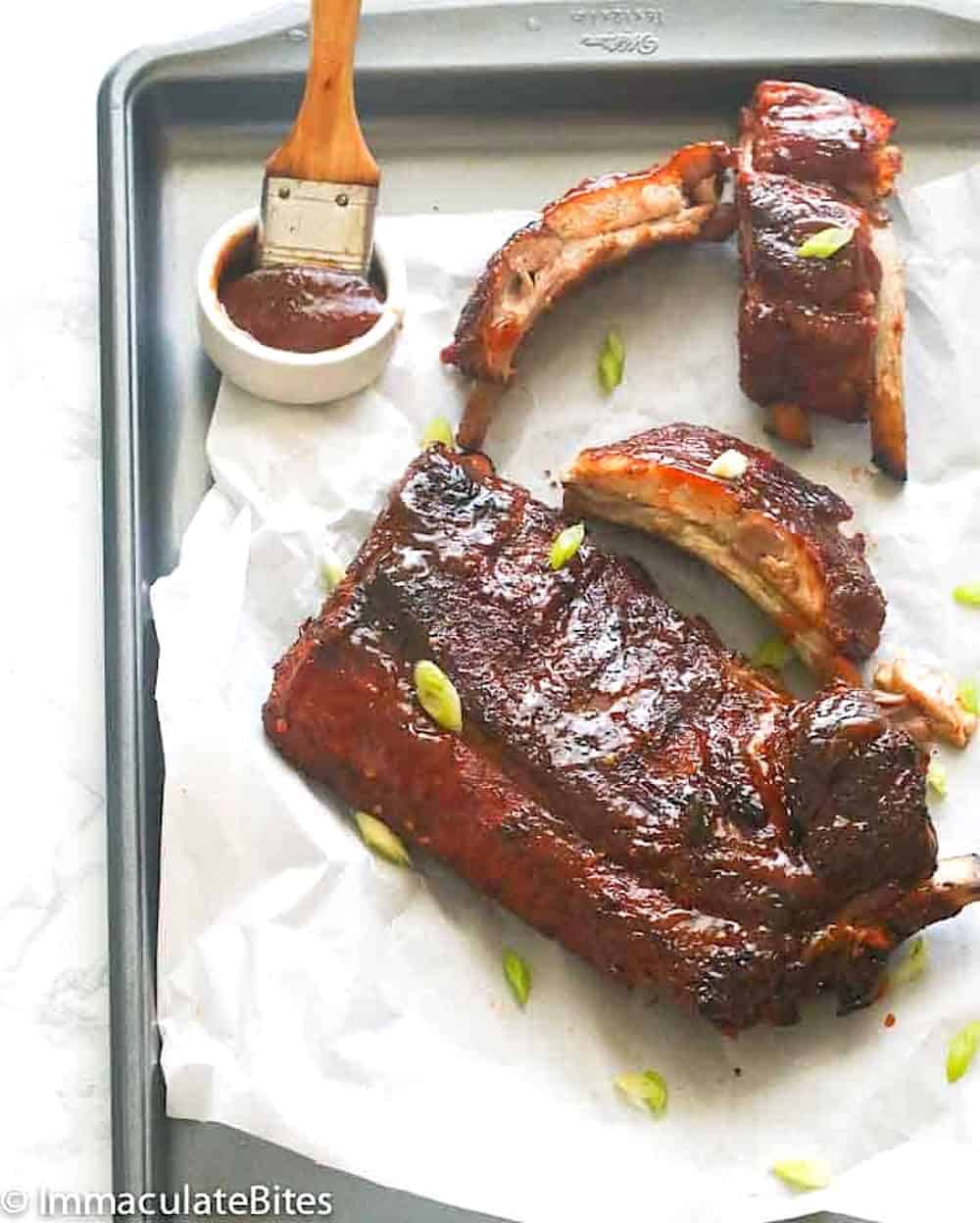 Serving up a tray of baby back ribs slathered with homemade BBQ sauce.