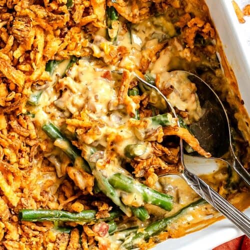 Scooping out a serving of green bean casserole made from scratch for a happy holiday dinner.