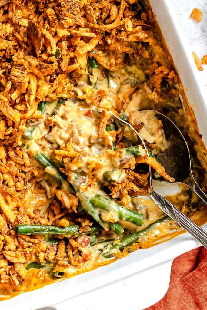 Scooping out a serving of green bean casserole made from scratch for a happy holiday dinner.