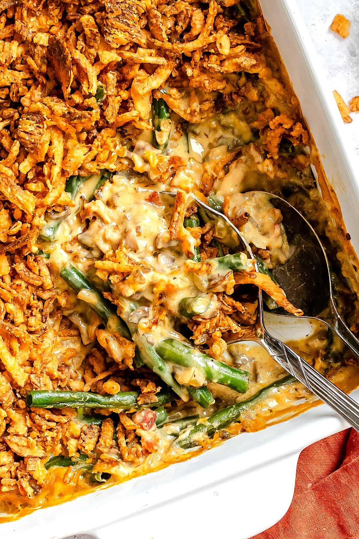 Scooping out a serving of green bean casserole made from scratch for a happy holiday dinner.