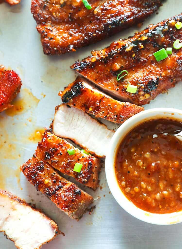 Slicing pork belly fresh off the grill for a delicious bacon alternative.