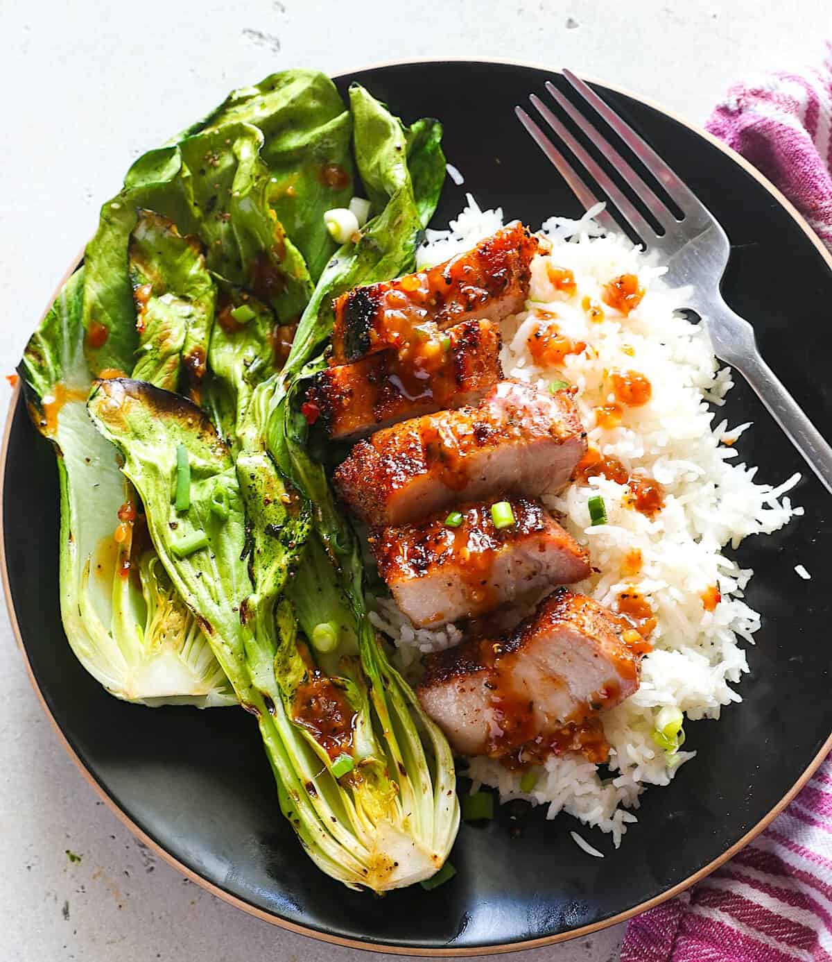 Enjoying grilled pork belly with rice and grilled bok choy.