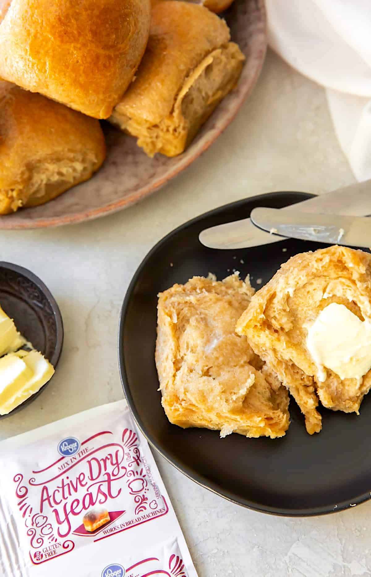 Enjoying honey wheat rolls with butter for a tasty snack.
