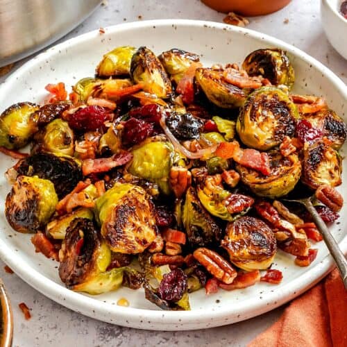 Loaded holiday Brussels sprouts perfectly glazed with a maple balsamic reduction, and made even better with bacon, pecans, and cranberries.