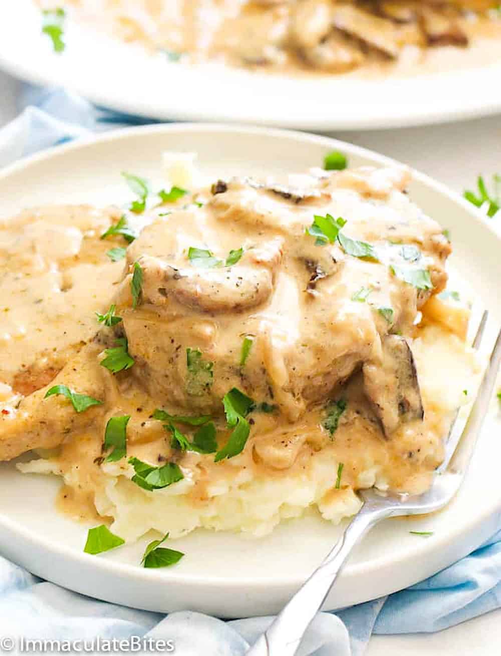Serving tender pork chops with mushroom gravy over garlic mashed potatoes for a satisfying weeknight dinner.